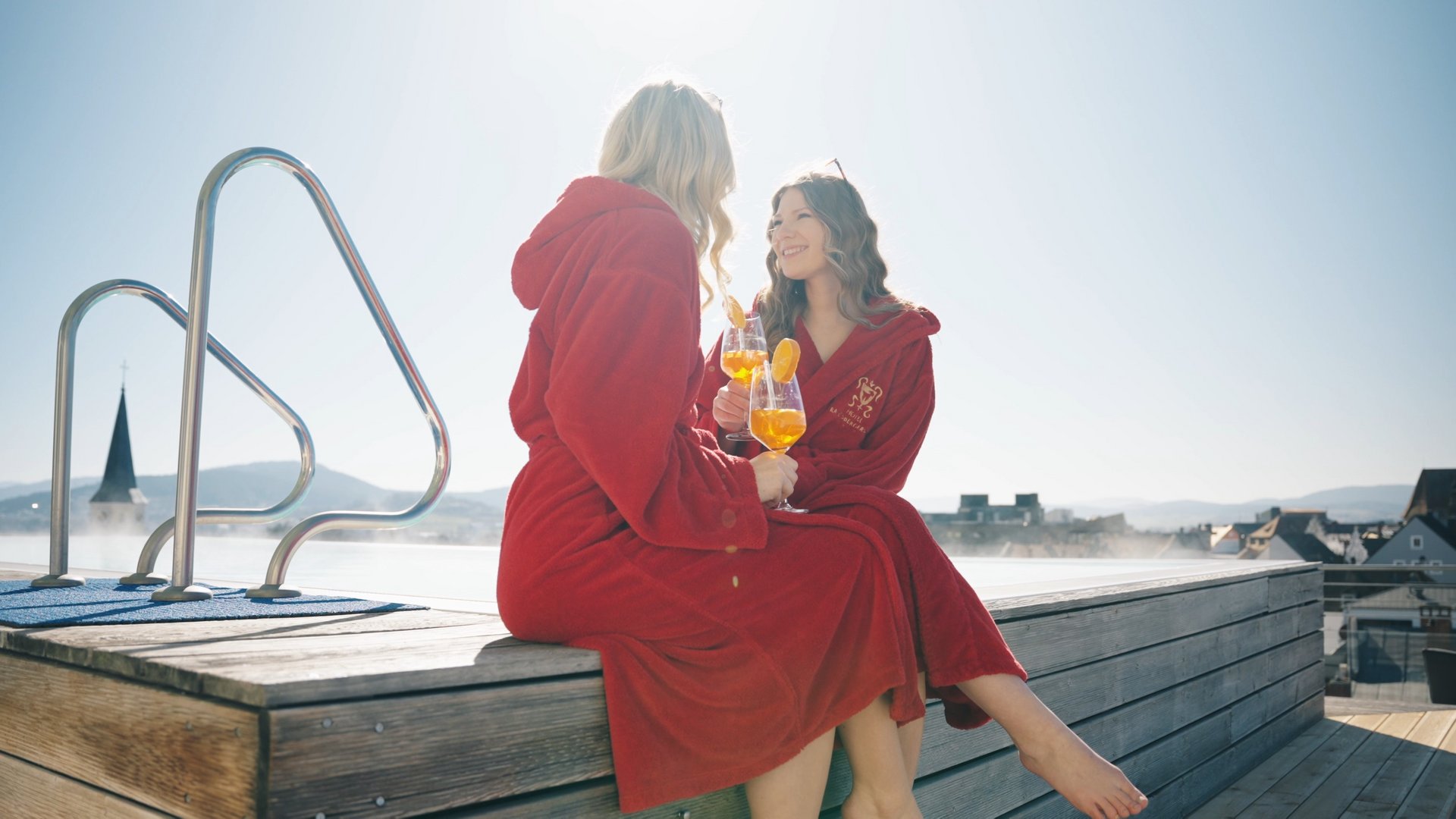 Our hotel with pool in Bavaria Zwei Gäste im Bademantel genießen Aperitif am Skypool des Randsbergerhof in Cham, Bayerischer Wald